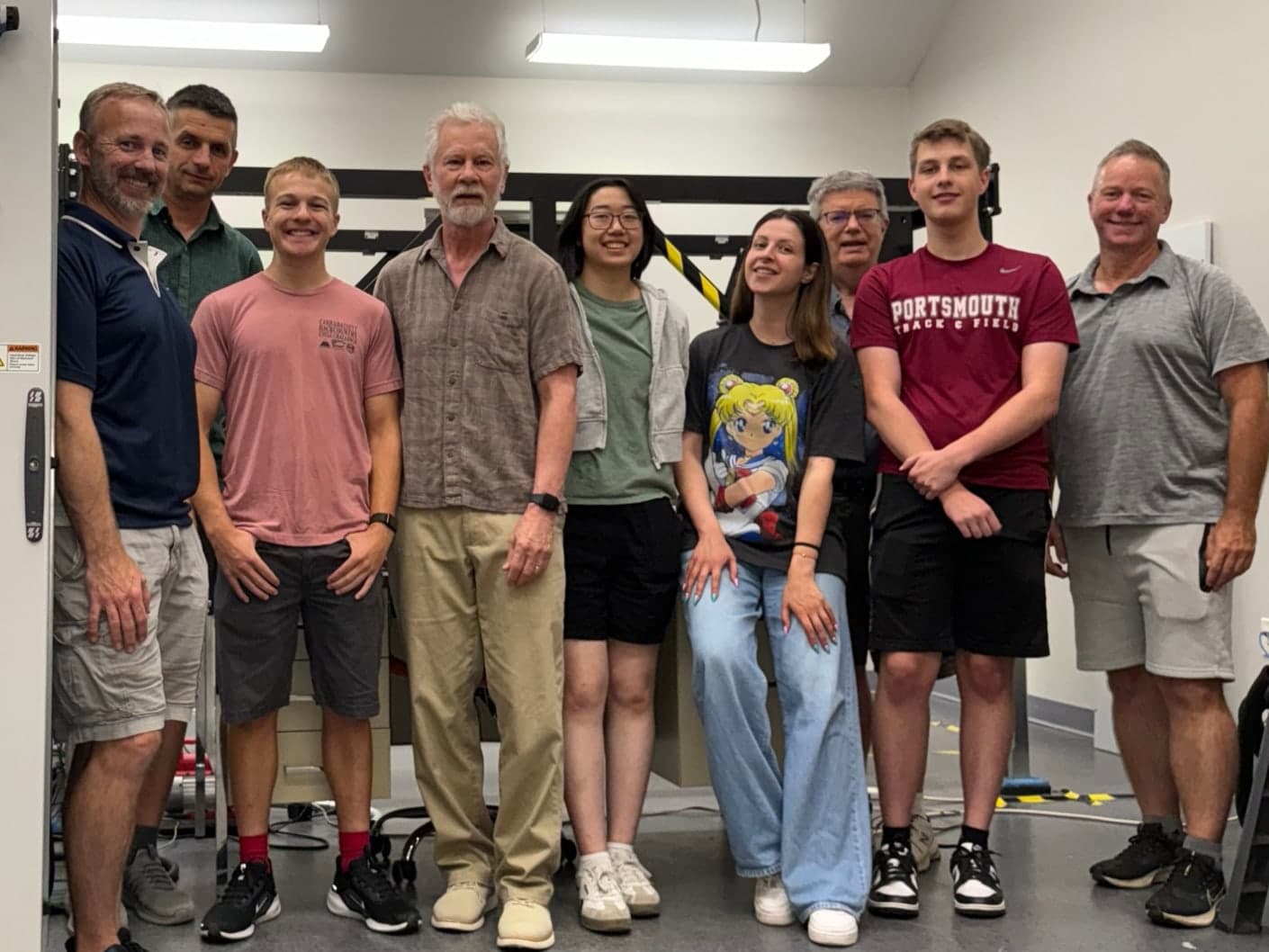 Nine members of the LiDAR Space team standing together in the laboratory.